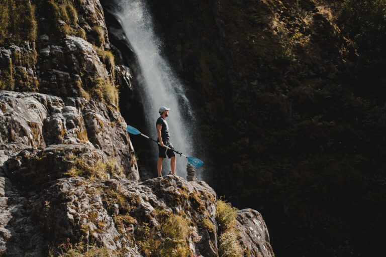 Men with paddle next to waterfall - Kayaking - Norway fjord - hiking in Norway - kayaking - from Brussels airport