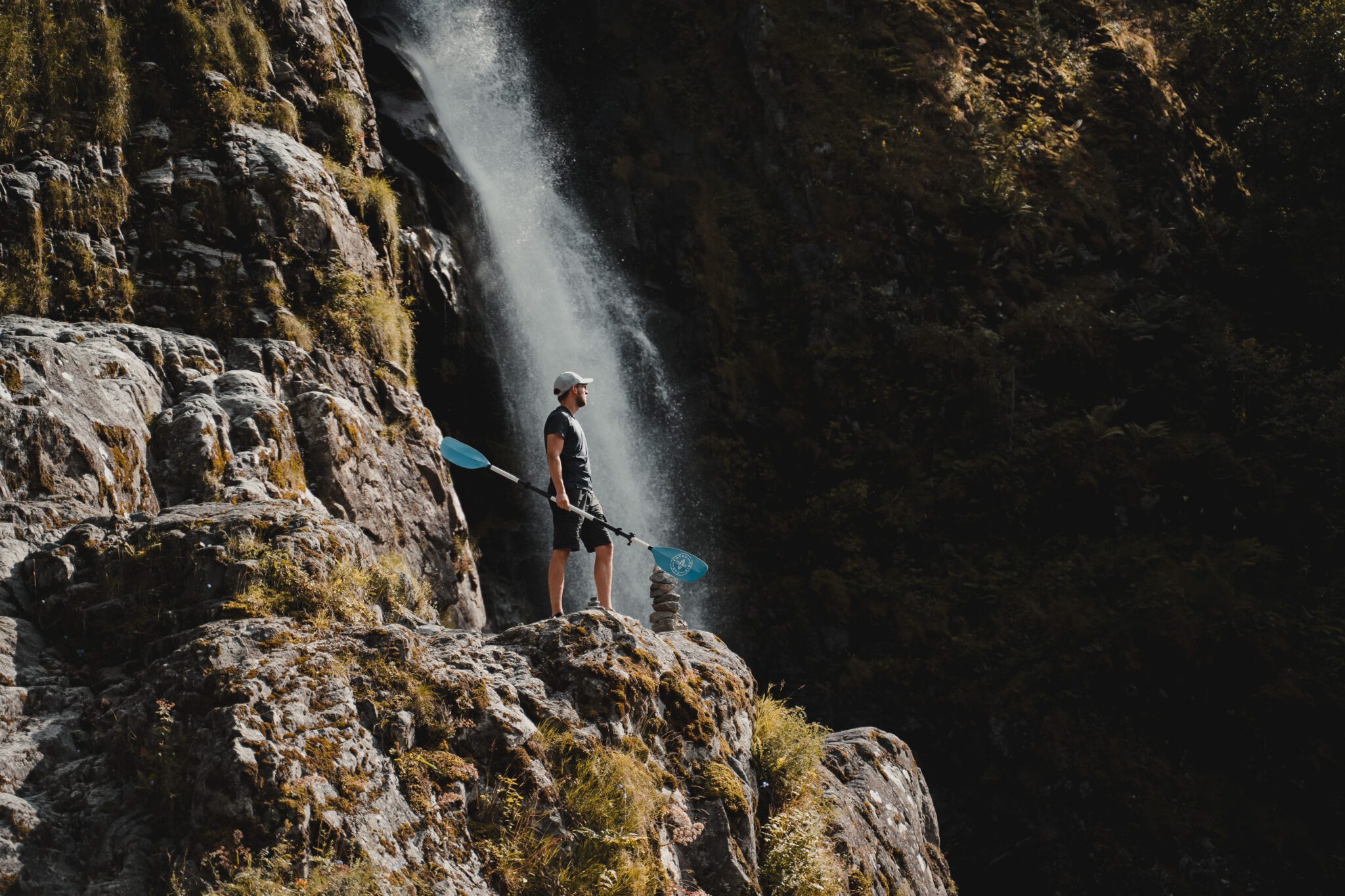 Men with paddle next to waterfall - Kayaking - Norway fjord - hiking in Norway - kayaking - from Brussels airport